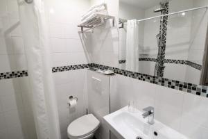 巴黎比利牛斯酒店的白色的浴室设有卫生间和水槽。