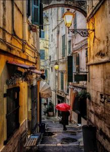 圣雷莫Casa Mirka的带着红伞沿着小巷走的人