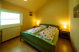 帕彭堡Ferienhaus Vergissmeinnicht的一间卧室配有带枕头的绿色床和窗户。