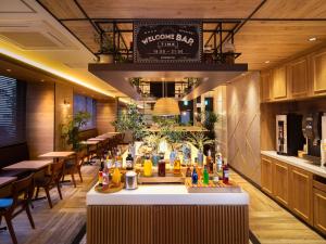 冈山Super Hotel Okayama Station Higashiguchi的餐厅设有酒吧,配有桌椅