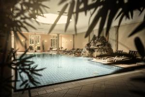 巴特贝德凯萨波塞夫罗曼蒂克酒店的大楼内带躺椅的大型游泳池