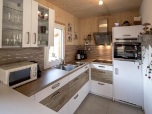穆劳附近圣洛伦岑Modern Wooden Chalet in Sankt Georgen ob Murau with Jacuzzi的厨房配有白色冰箱和水槽