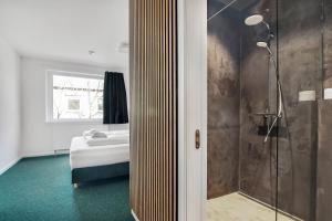 哥本哈根司丽普旅舍的带淋浴的浴室和1间带1张床的卧室