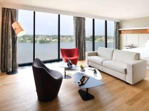 阿比让普尔曼阿比让酒店的带沙发和椅子的客厅以及大窗户。