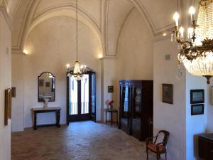 马泰拉帕拉索维切康泰酒店的一个带吊灯的大走廊和一间带桌子的房间