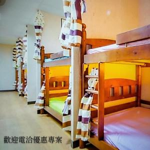 基隆Non-profit bee home的客房内的一排双层床