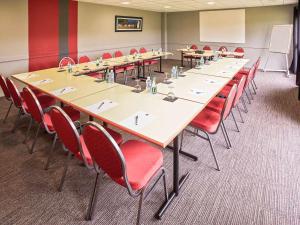 欧赖欧赖宜必思酒店的一间会议室,配有长桌子和红色椅子