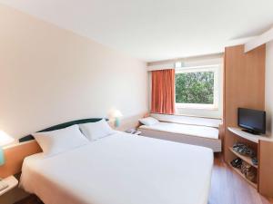 穆尔西亚宜必思穆尔西亚酒店的卧室设有一张白色大床和一扇窗户。