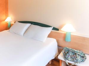 穆尔西亚宜必思穆尔西亚酒店的卧室配有白色的床和蓝灯