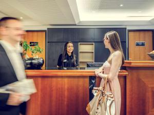 慕尼黑慕尼黑老城美居酒店的妇女正在现金登记册上登记