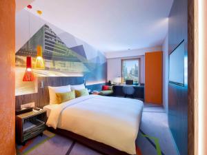 首尔首尔江南大使宜必思尚品酒店的酒店客房设有一张大床和一张书桌。