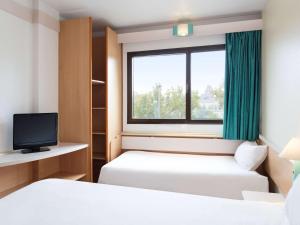 萨拉戈萨B&B HOTEL Zaragoza Centro的酒店客房设有两张床和窗户。