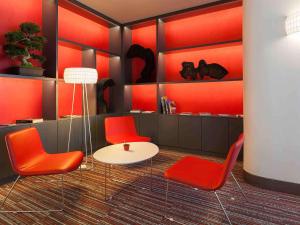 里斯本里斯本美居酒店的一间设有红色椅子和白色桌子的房间
