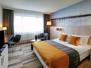 格丁尼亚格丁尼亚美居中心酒店的酒店客房设有一张大床和一张书桌。