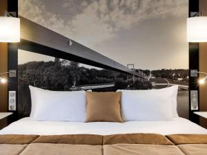 塞尔吉塞尔吉蓬图瓦兹中心美居酒店的一间卧室配有一张床,享有桥梁的景色