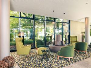 埃森埃森美居酒店广场店的大堂设有椅子、桌子和窗户。