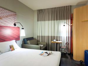 特雷西纳Ibis Teresina的酒店客房配有一张床、一把椅子和一张沙发