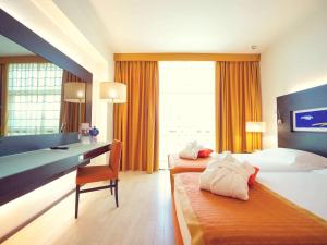 锡拉库扎锡拉库扎美居酒店的酒店客房配有两张床和一张书桌