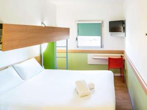 莱斯特莱斯特宜必思快捷酒店的卧室配有白色的床、书桌和窗户。