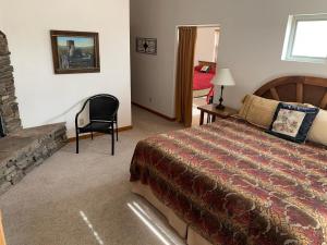 埃斯卡兰特Slot Canyons Inn Bed & Breakfast的一间卧室配有一张床、一把椅子和一个壁炉