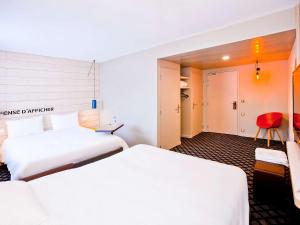 香槟沙隆ibis Styles Chalons en Champagne Centre的酒店客房,设有两张床和一张红色椅子