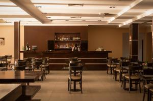 康考迪亚Hathor Concordia的一间带桌椅的餐厅和一间酒吧