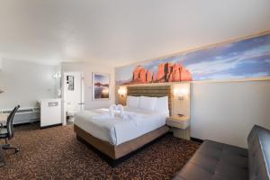 塞多纳格林豪泰塞多纳酒店的酒店客房设有一张床,墙上挂有绘画作品
