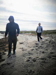 卡琳贡Käringöns Vandrarhem的两人在沙滩上散步