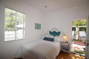 洛杉矶贝弗利山名人之家别墅的白色的卧室设有床和窗户