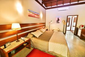 皮帕班奎坦戈酒店的一间卧室配有一张床和一张带台灯的桌子