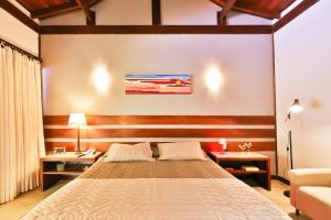 皮帕班奎坦戈酒店的一间卧室配有床、两张桌子和一张沙发