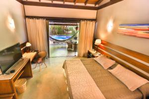 皮帕班奎坦戈酒店的一间卧室配有一张床、一台电视和一个庭院。