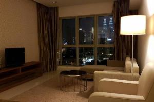 吉隆坡KLCC Regalia Suites Infinity Pool Kuala Lumpur的带沙发、电视和窗户的客厅
