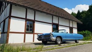 芬肯施泰因Vintage House am Faaker Seebach的停在大楼前的蓝色汽车