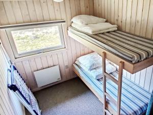 罗胡斯6 person holiday home in Pandrup的小房间设有两张双层床和窗户