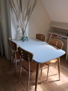 阿赫特克克Apartment Zonnehoek的客房内的白色餐桌和椅子