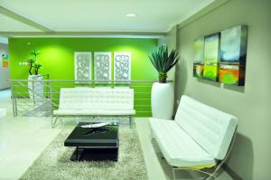 哈博罗内旅程住宿的客厅配有两把白色椅子和绿色墙壁
