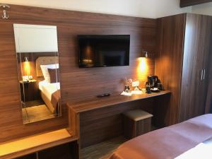 凯尔克海姆博斯特酒店的酒店客房配有一张床和一张书桌及一台电视