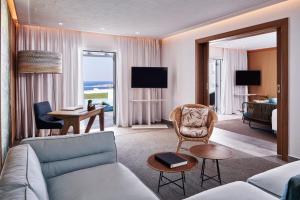 米克诺斯城Myconian Kyma, a Member of Design Hotels的带沙发的客厅和带沙发床的房间