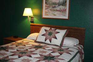 WibauxRodeway Inn Gateway to Medora T-Roosevelt & Makoshika State Park的一间卧室配有床,床上装有被子