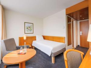 弗莱堡诺富特弗赖堡音乐厅酒店的小型酒店客房配有一张床和一张桌子