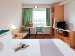 阿尔考空宜必思马德里阿尔科尔孔崔萨瓜斯酒店的配有一张床、一张书桌和一扇窗户的酒店客房