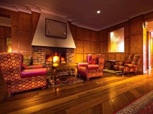 堪培拉堪培拉美居酒店的客厅配有椅子和壁炉