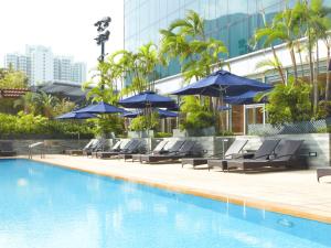 香港香港诺富特东荟城酒店的一个带躺椅和遮阳伞的游泳池