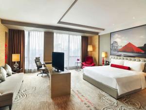 广州Sofitel Guangzhou Sunrich的酒店客房设有一张大床和一间客厅。