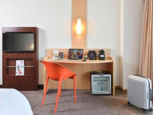 科特赖克宜必思科特赖克市区酒店的酒店客房设有一张桌子、一把椅子和一台电视。