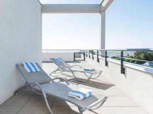 尼斯尼斯机场诺富特套房酒店的阳台配有2把椅子和毛巾