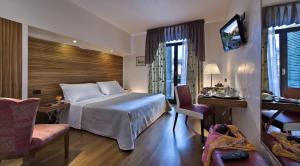 都灵贝斯特韦斯特皮耶蒙缇斯酒店的酒店客房,配有一张床、一张桌子和椅子