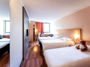 萨尔拉拉卡内达Ibis Sarlat Centre的酒店客房设有三张床,床上有泰迪熊