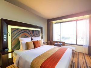 加尔各答加尔各答诺富特酒店及公寓的一间酒店客房,设有一张大床和一个大窗户